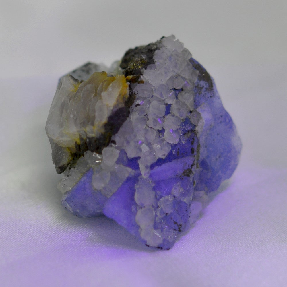 Fluorite avec calcite, quartz et sulfure de 36g sous lampe UV du Maroc