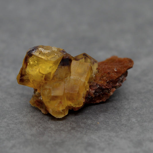 Amas de fluorite jaune zonée couleur prune sur gangue rouge terre 22g