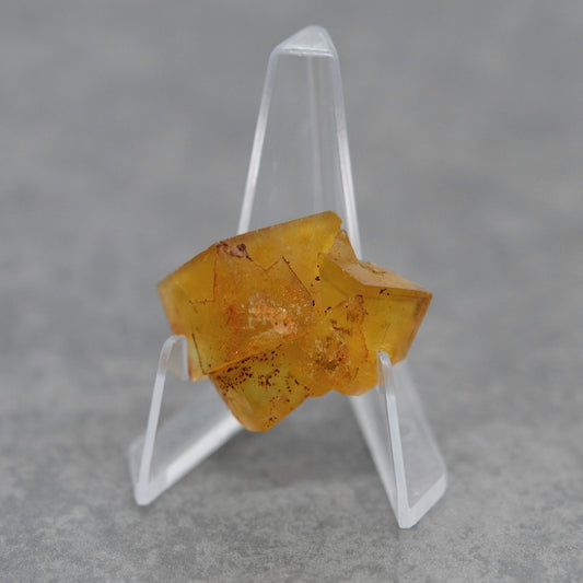 Pierre brute fluorite jaune miel foncée de 17g sur présentoir
