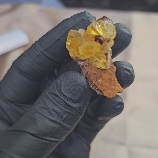 Fluorite jaune en cubes sur microcristaux rouges scintillants d'Aouli au Maroc 22g
