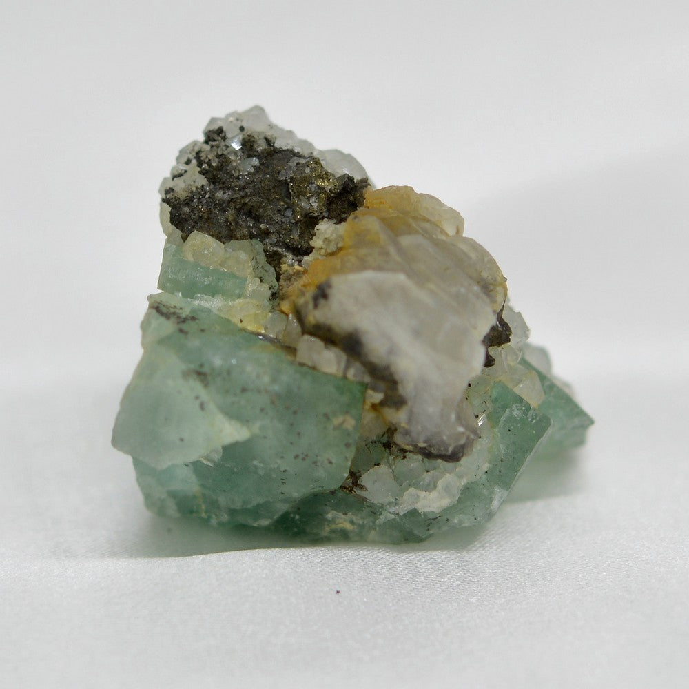 Sulfure de pyrite, calcite oxydée et quartz sur fluorite vert d'eau de 36g de la mine d'El Hammam au Maroc